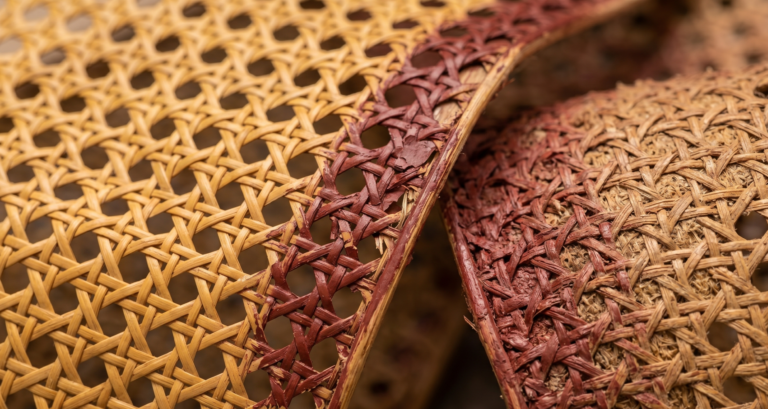 Close-up anatomy of rattan webbing showing peeling paint on the smooth outward skin versus the rough inward face.